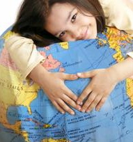 Little girl hugging a pillow with the globe painted on it.
