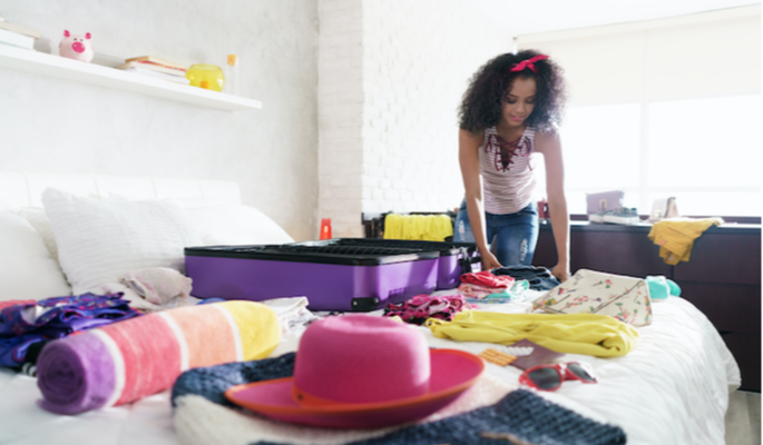 excited-young-black-woman-packing-bags-for-holidays-pretty-hispanic-girl-preparing-sui-SBI-330550216 copy-1-1